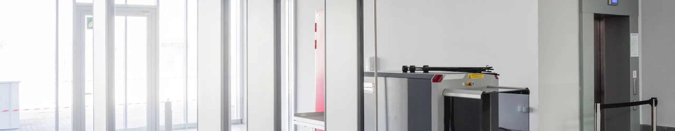 Metal detector frame and X-ray machine for checking luggage and hand baggage at entrance to public building. Checkpoint with security and anti-terrorist measures.